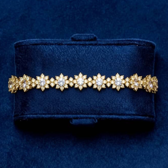 Gold bracelet with diamonds on a blue velvet background