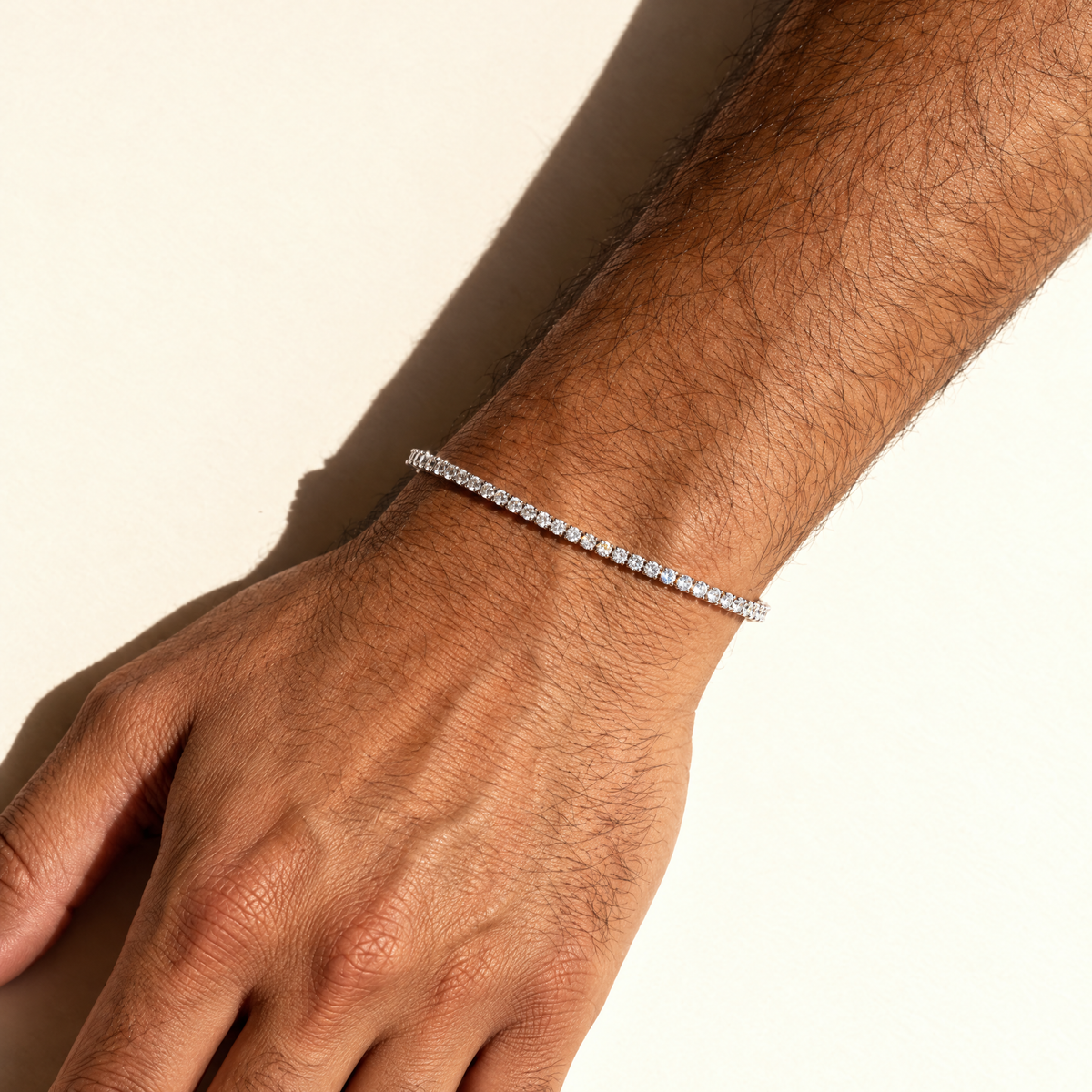 Men's 2MM Moissanite Tennis Bracelet in silver worn by an Arab male model